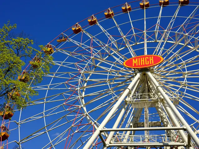 The Ferris wheel in Gorky Park, with a red Minsk sign at its hub, against a deep blue sky