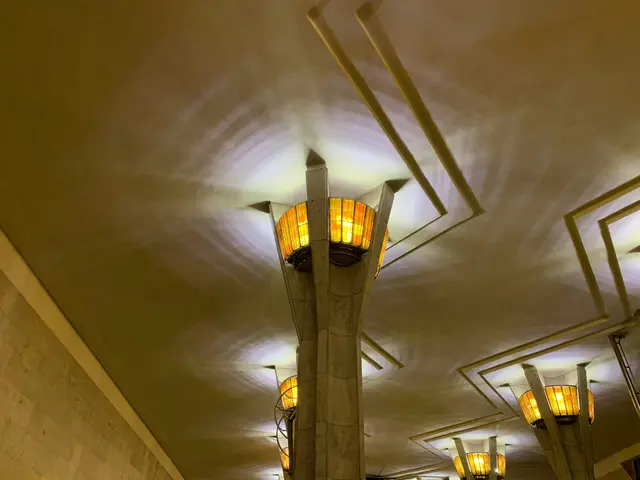 Warm lantern-like lamps on angular columns under the vaulted ceiling of a Minsk metro station