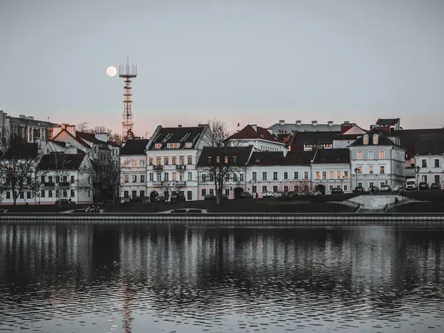 A row of white old houses with dark roofs in Trinity Suburb at dusk, a full moon rising and the scene mirrored in the river